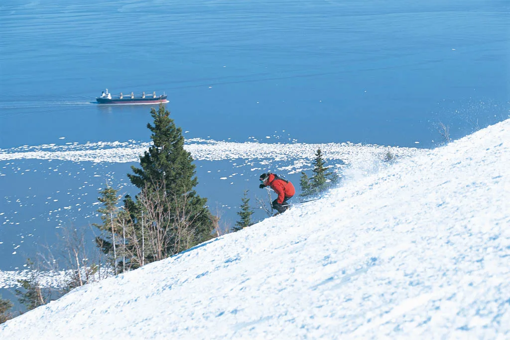Skieur au sommet du Massif de Charlevoix, vue sur le Saint-Laurent